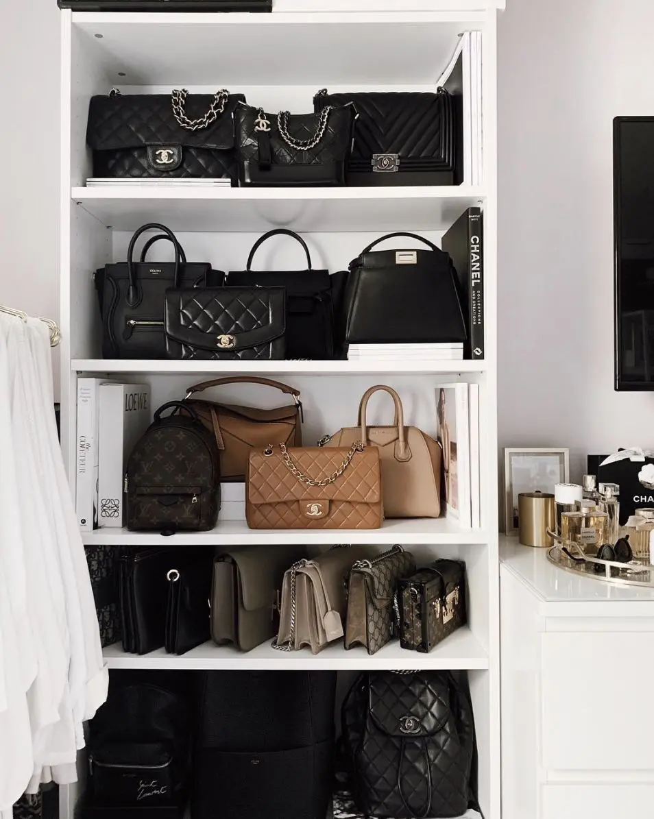 White shelving unit displaying mostly black and neutral handbags in a precise monochromatic arrangement.