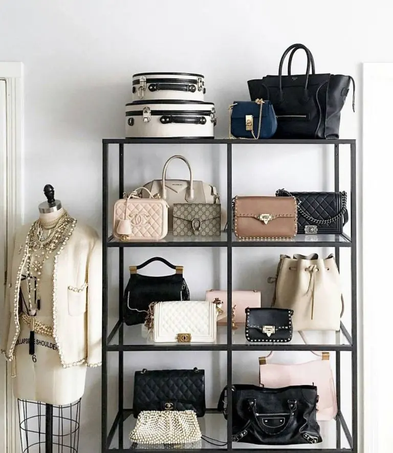 Black metal and glass shelving unit displaying designer handbags with a mannequin nearby.