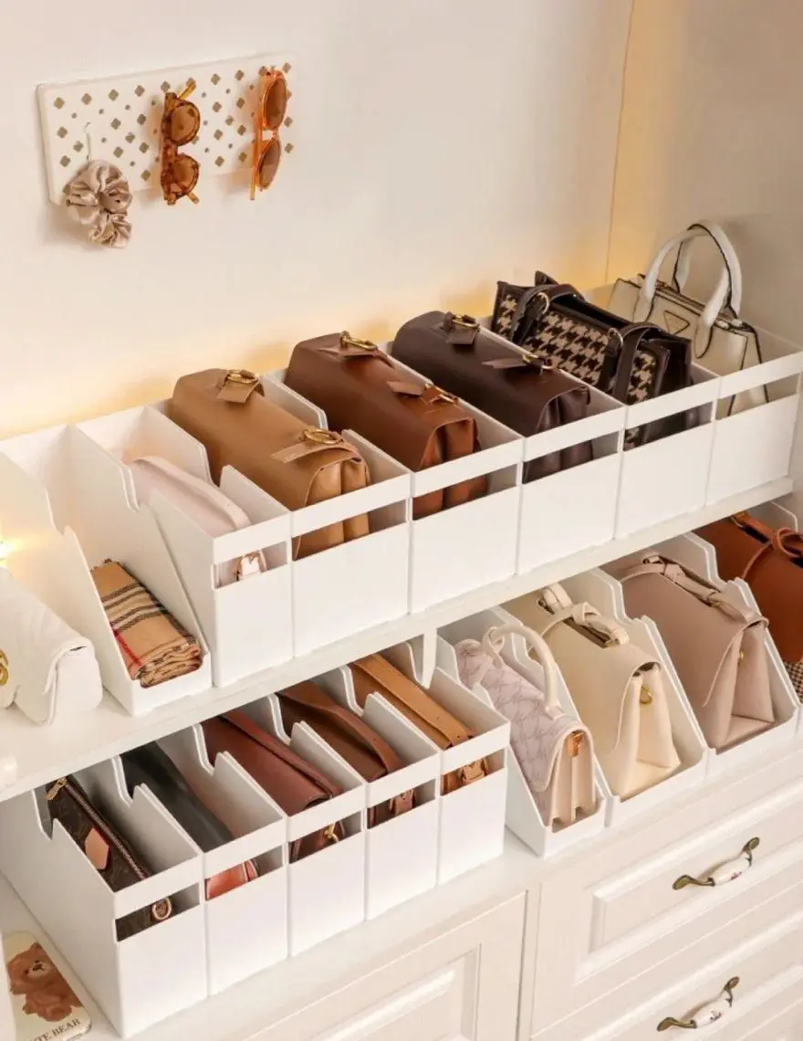Closet shelf with divided inserts keeping neutral handbags upright and separated.