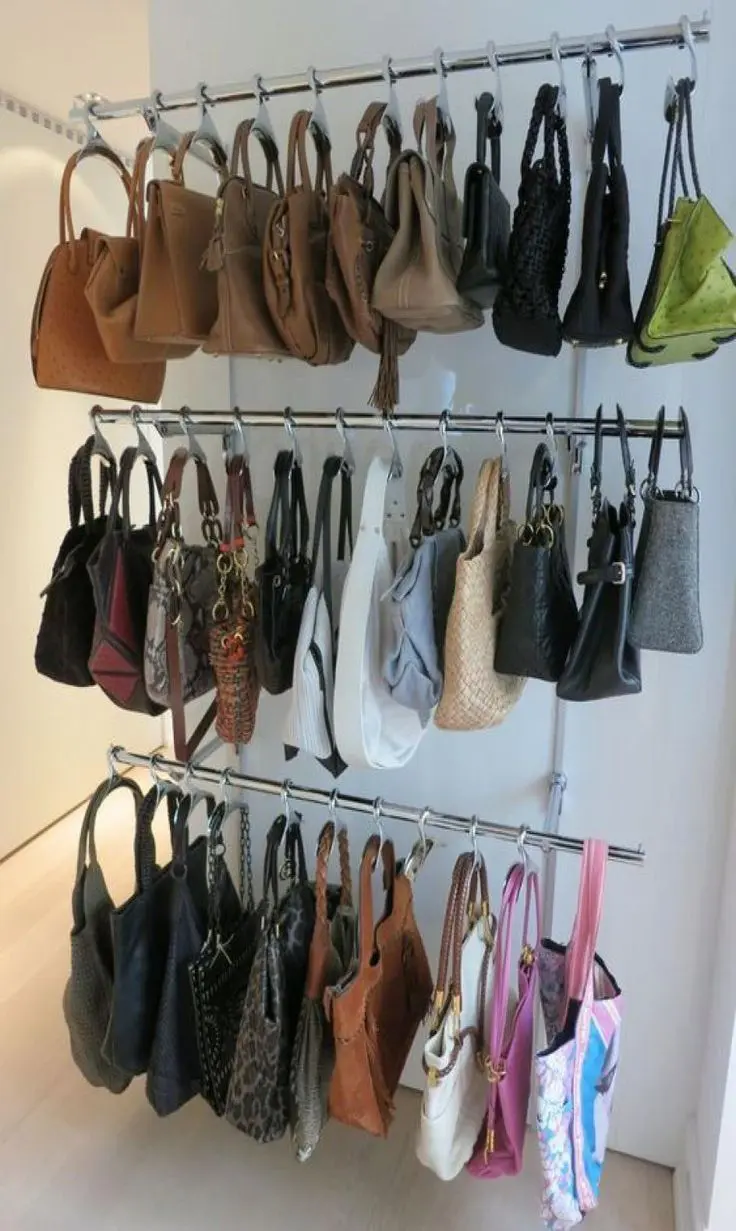 Hanging bar organizers with S hooks storing many handbags in a compact display.