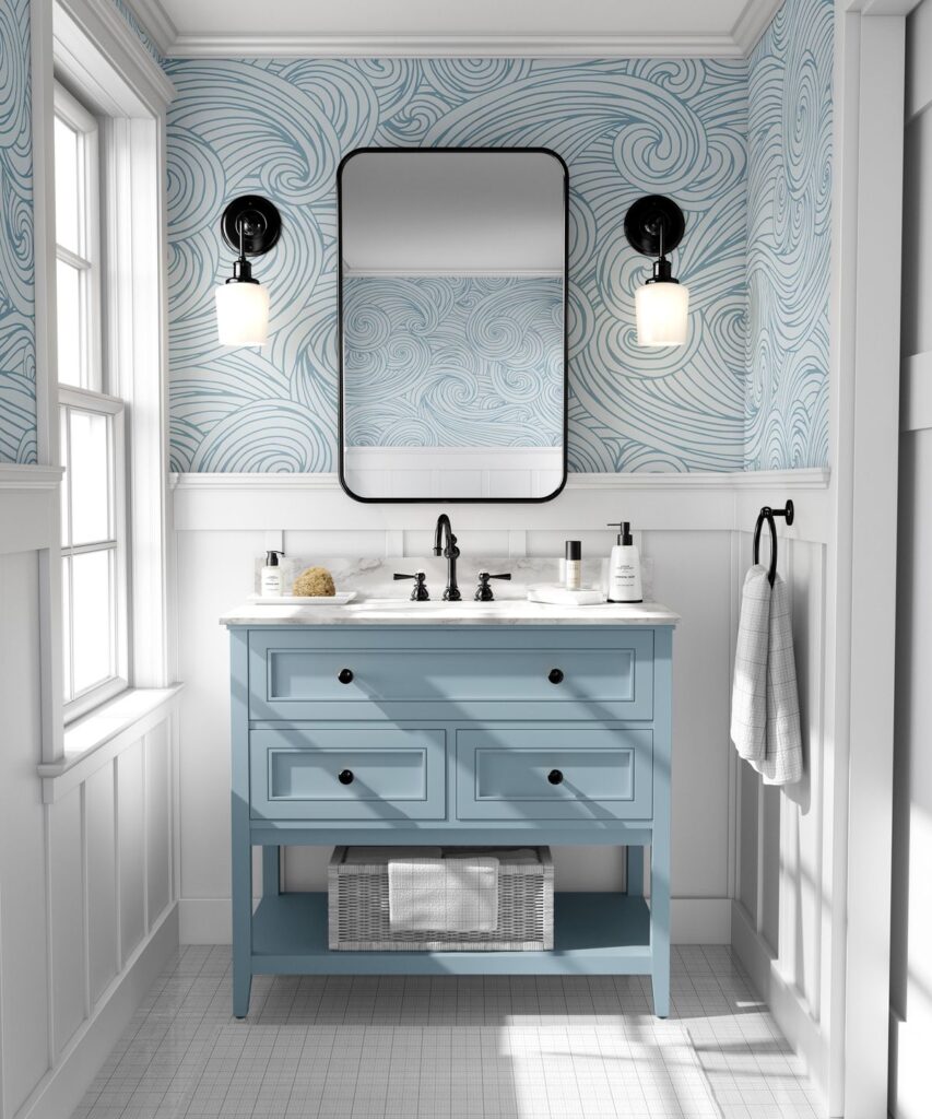 Ocean wave wallpaper in soft blues and whites creating a soothing, airy look in a small bathroom.