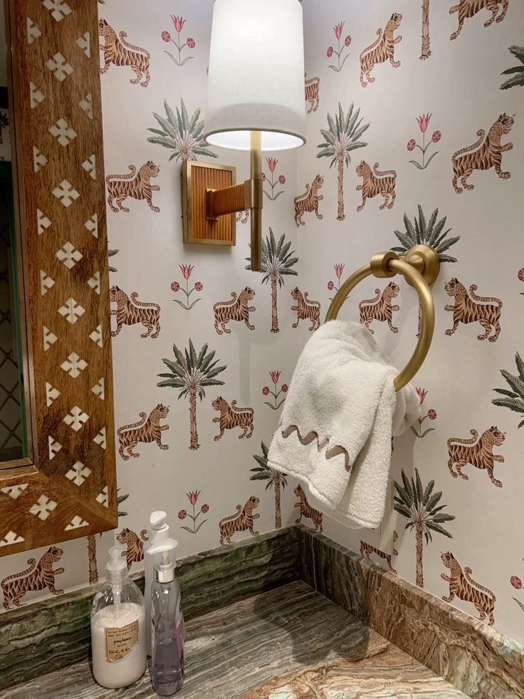 Colorful animal motif wallpaper in a small bathroom, full of whimsical characters.