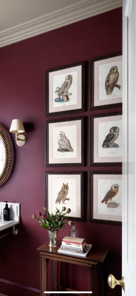Mauve bathroom with a gallery wall of framed artwork and a cozy pendant light.