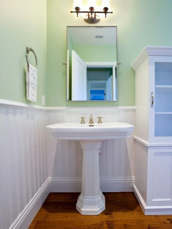 coastal bathroom with white pedestal sink and beadboard