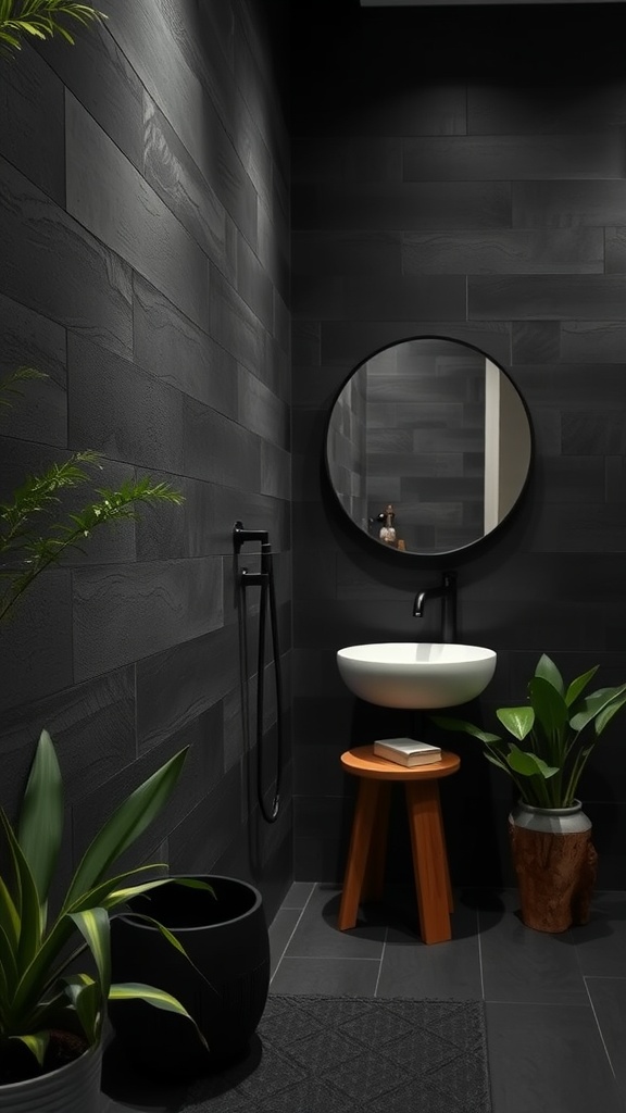 Modern dark bathroom with black walls, white sink, round mirror, wooden stool, and green plants.