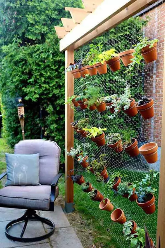 11 a cool and easy vertical garden composed of wood and chicken wire with terracotta plants with herbs is a cool way to get a kitchen garden without sacrificing much space