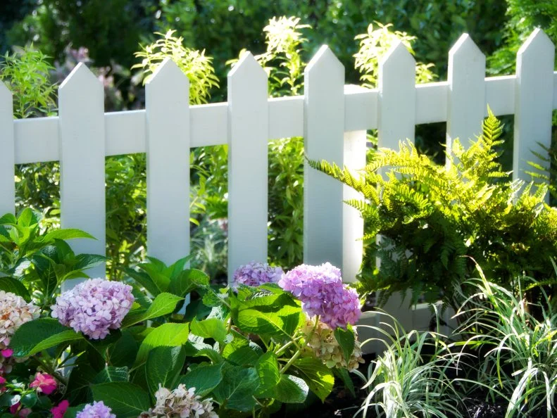 Charming white picket fence with flower garden