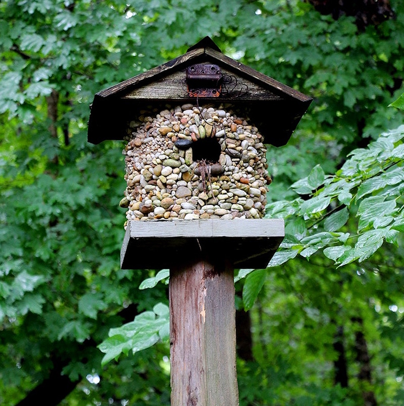Tall multi story birdhouse with stacked sections and multiple entry holes.