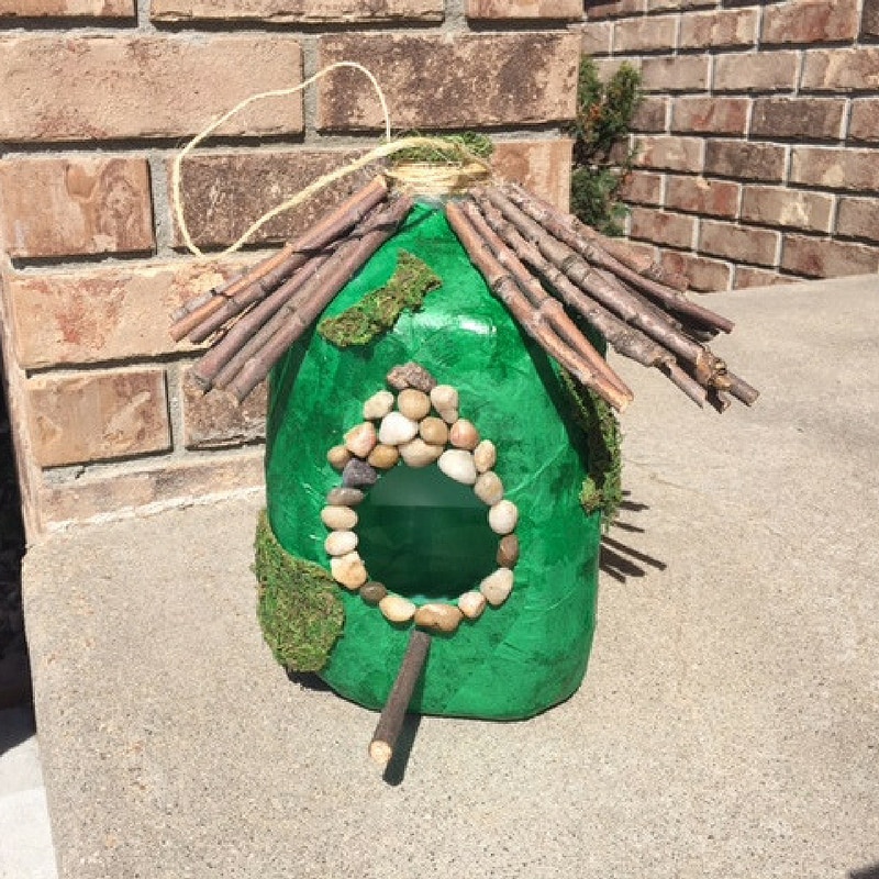 White birdhouse covered in colorful hand painted polka dots.