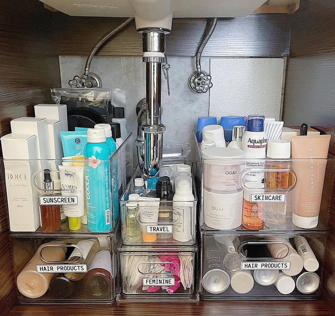 Clear tiered containers and rotating tray organizing products under bathroom sink
