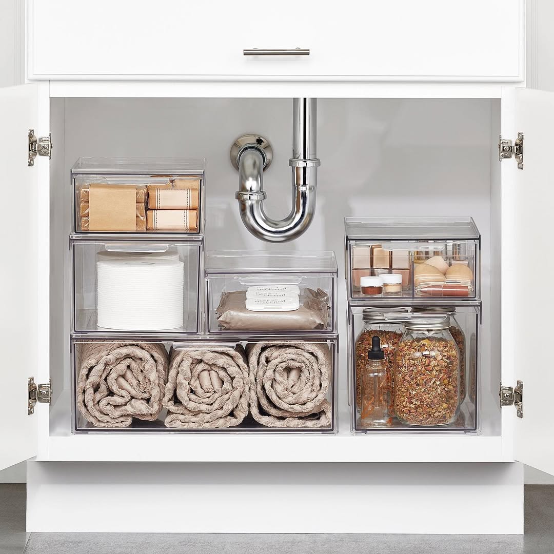 Open under-sink shelving with labeled white bins for face and body products