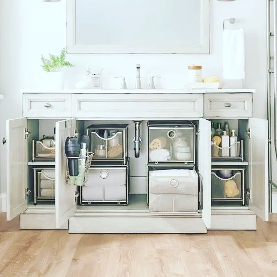 Clear stacked drawers organizing skincare and hygiene products under sink