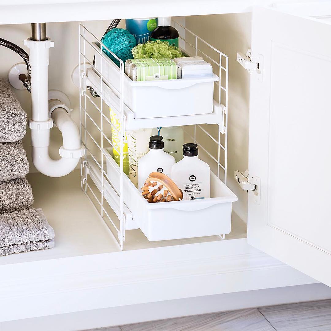 Pull-out drawers neatly organizing towels and hair tools under sink
