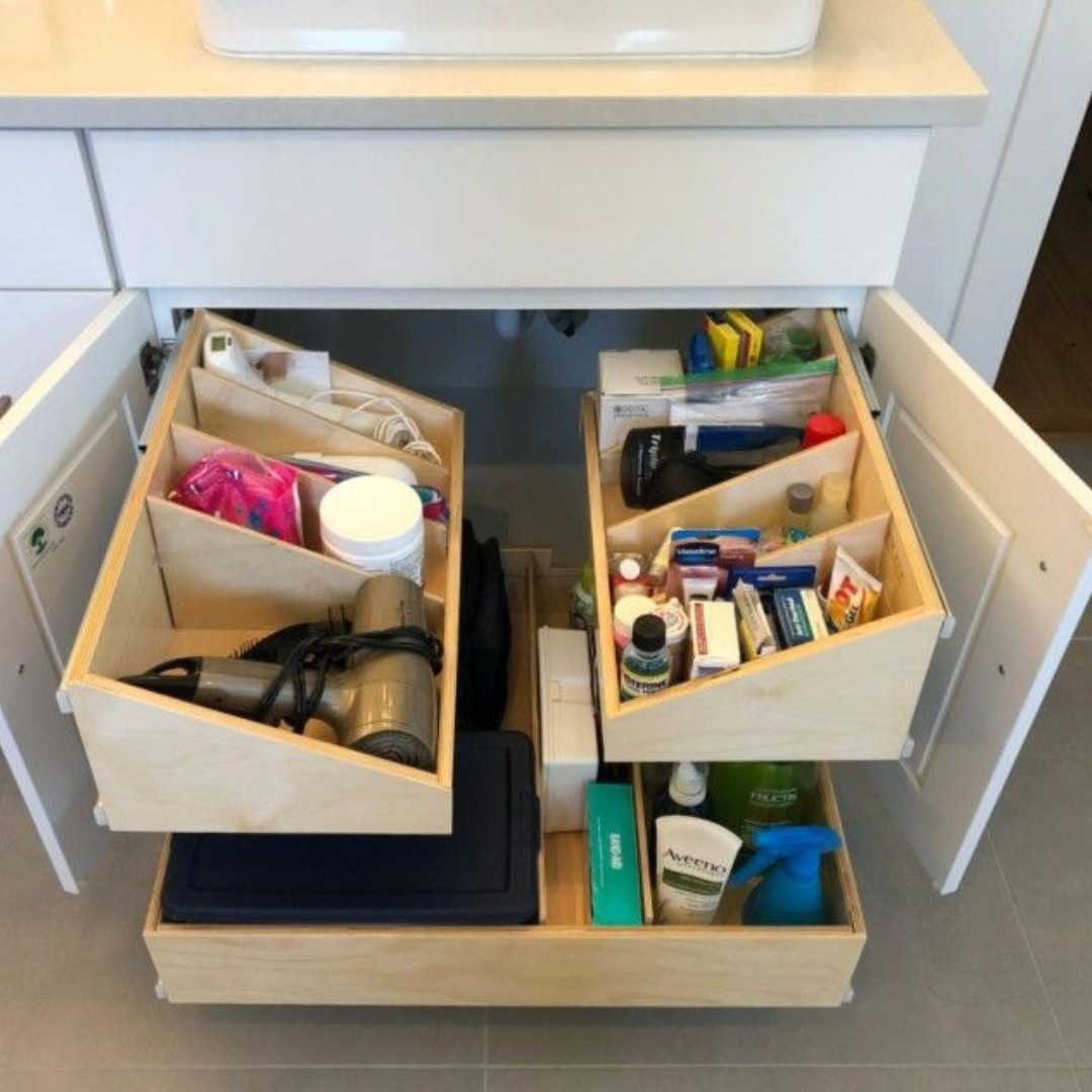 Family bathroom storage with bath toys and clear bins under sink