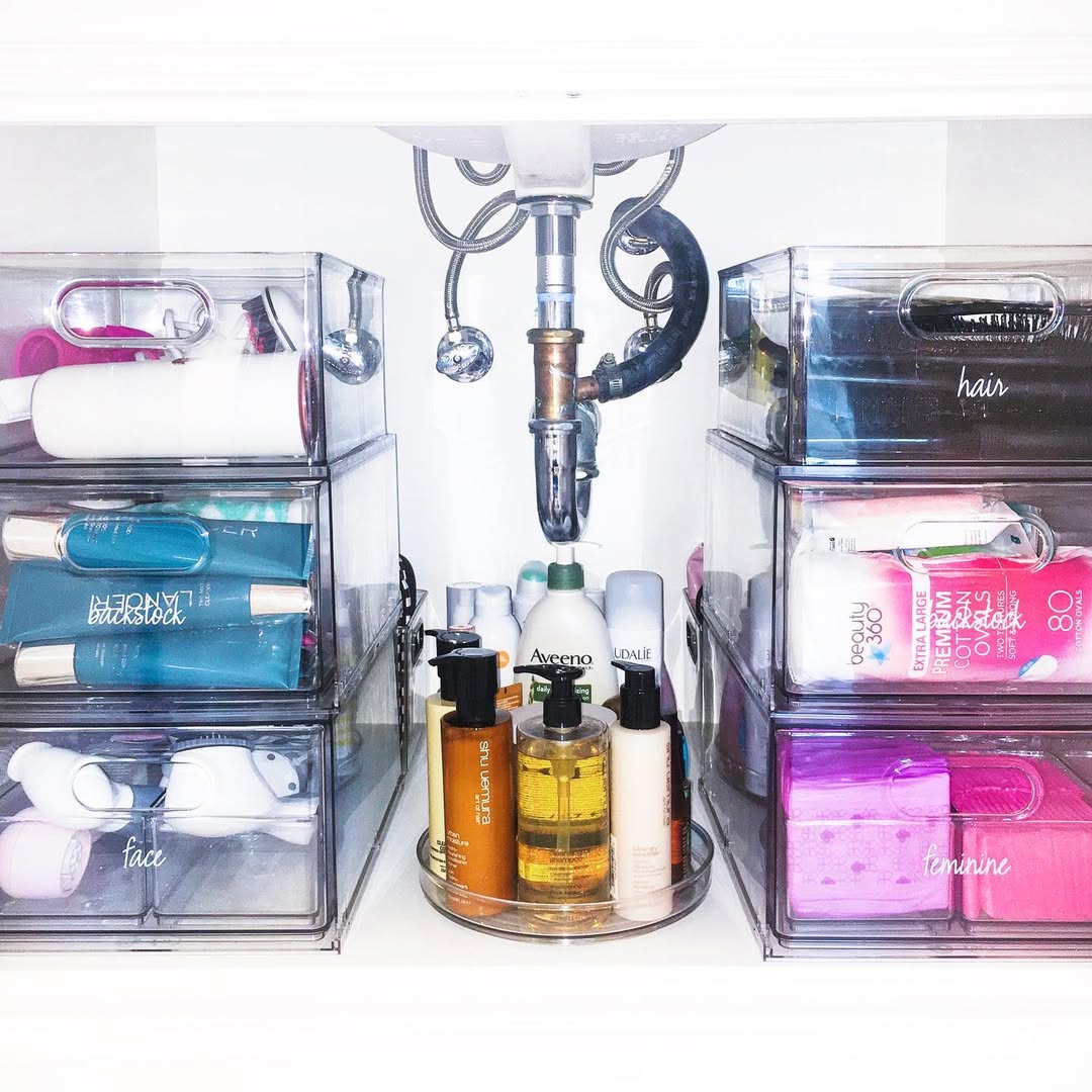Clear divided bins organizing cleaning supplies under sink